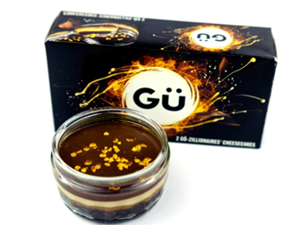 A Gu Zillionaires Cheesecake flavoured dessert pot picture in front of it's packaging.