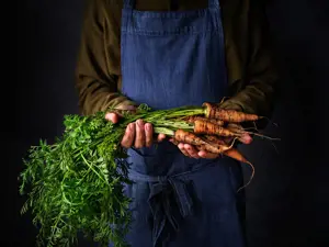 Man holding organic carrots