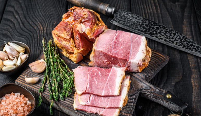 Sliced bacon on platter with knife